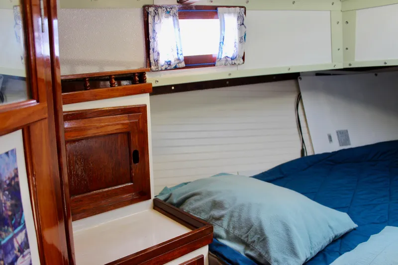 Slide: The Image of Cozy cabin interior of a 1975 Downeast 38 sailboat with wooden accents and bedding. - 65