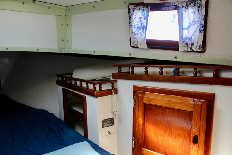 Slide: The Image of Cozy cabin interior of a 1975 Downeast 38 sailboat with wooden accents and nautical decor. - 66