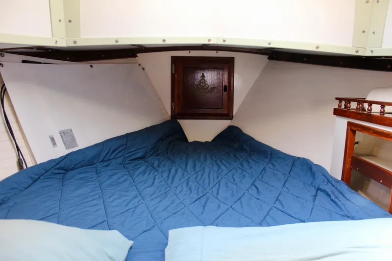 Slide: The Image of Cozy cabin interior of a 1975 Downeast 38 sailboat with blue bedding. - 67