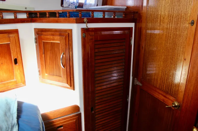 Slide: The Image of Wooden interior of a 1975 Downeast 38 boat, featuring cabinets and doors. - 68