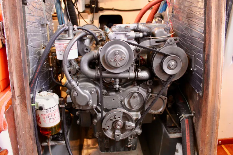 Slide: The Image of Engine of a 1975 Downeast 38 boat, showcasing mechanical components and belts. - 71
