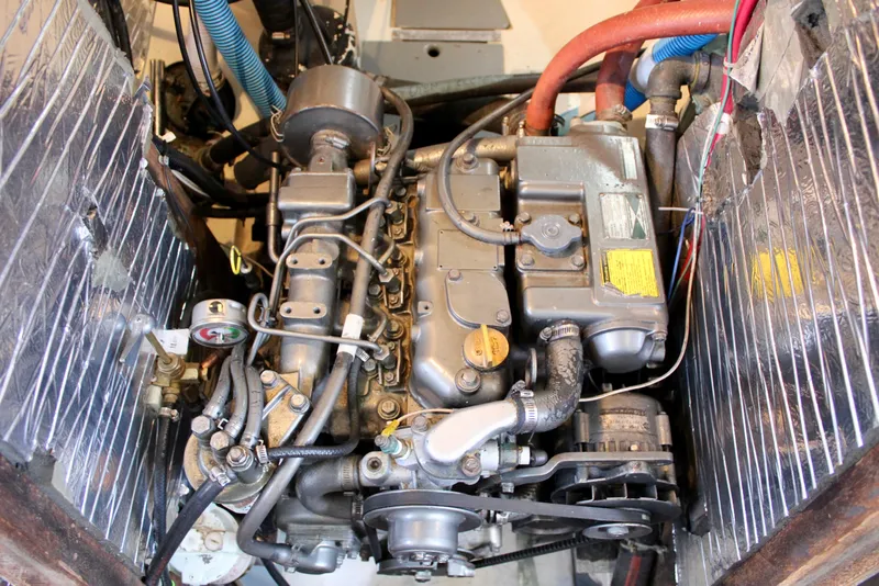 Slide: The Image of Engine compartment of a 1975 Downeast 38 boat, showcasing mechanical components and wiring. - 72