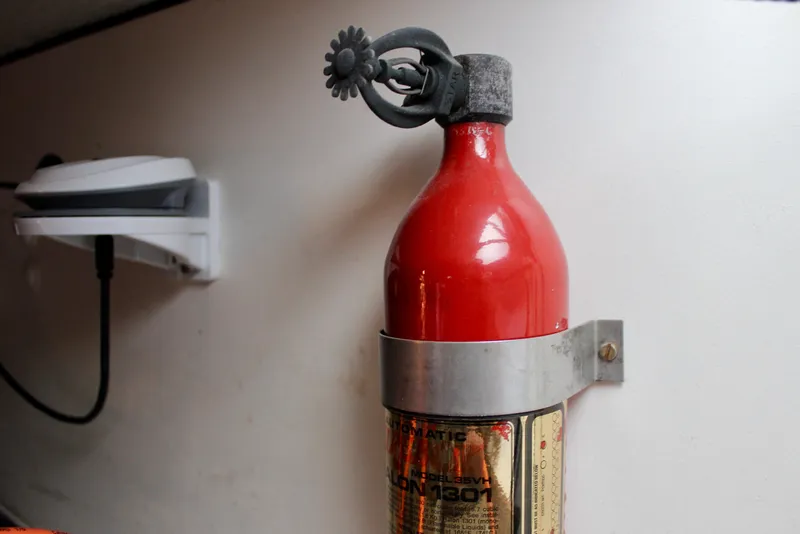 Slide: The Image of Red fire extinguisher mounted on a 1975 Downeast 38 boat interior wall. - 73