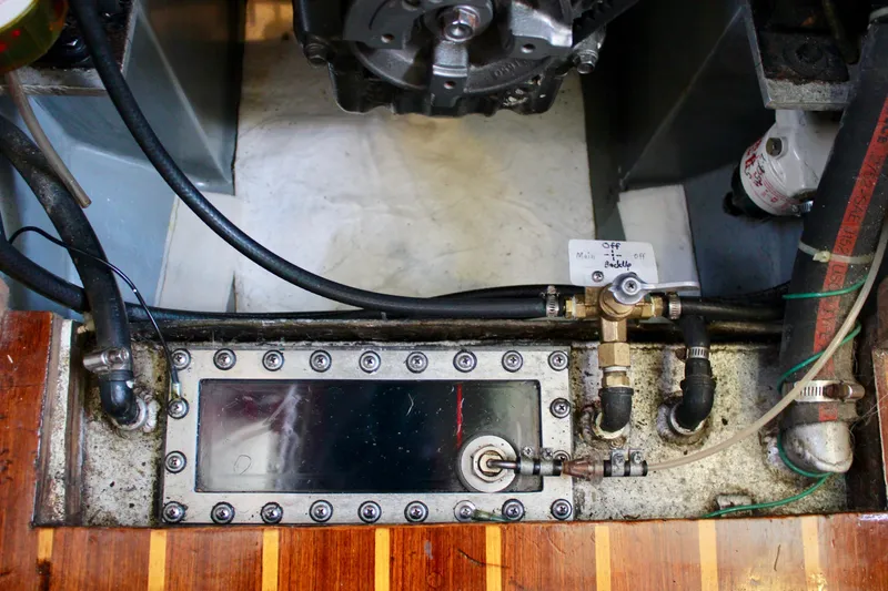 Slide: The Image of Engine compartment of a 1975 Downeast 38 boat, showing fuel lines and control valves. - 80