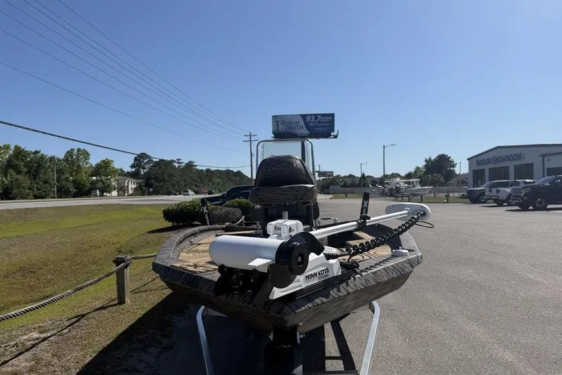 Slide: The Image of 2026 Xpress H22B Bay boat with Minn Kota motor displayed outdoors near a showroom. - 7