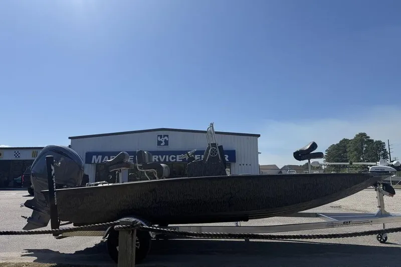 Slide: The Image of 2026 Xpress H22B Bay boat on trailer outside marine service center. - 11