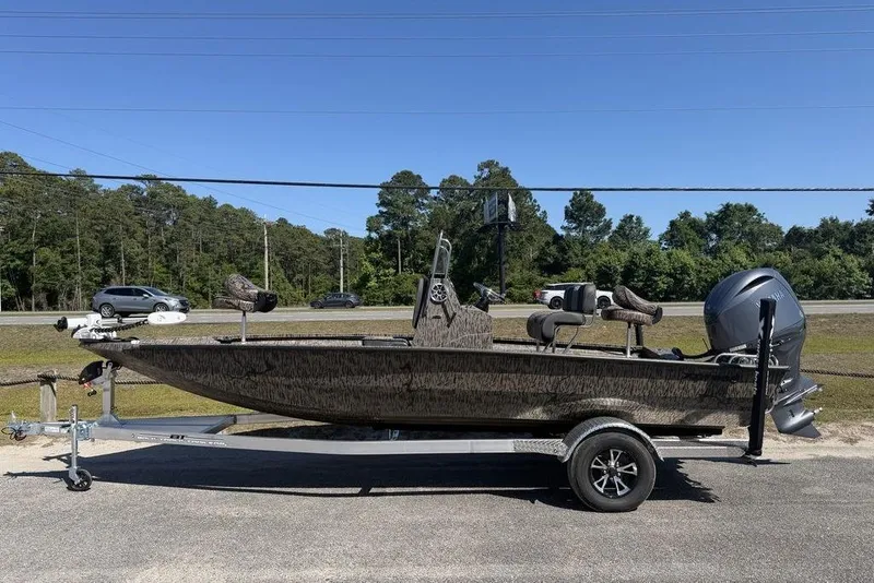 Slide: The Image of 2026 Xpress H22B Bay boat on trailer, parked roadside under clear blue sky. - 2
