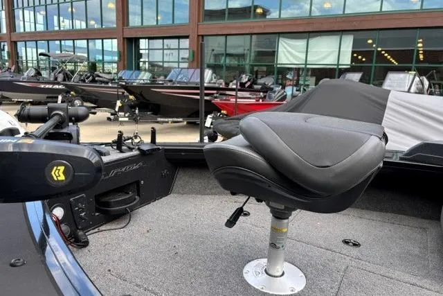 Slide: The Image of 2025 Tracker Targa V-19 WT Tournament Edition boat with swivel seat and motor, displayed outdoors. - 2