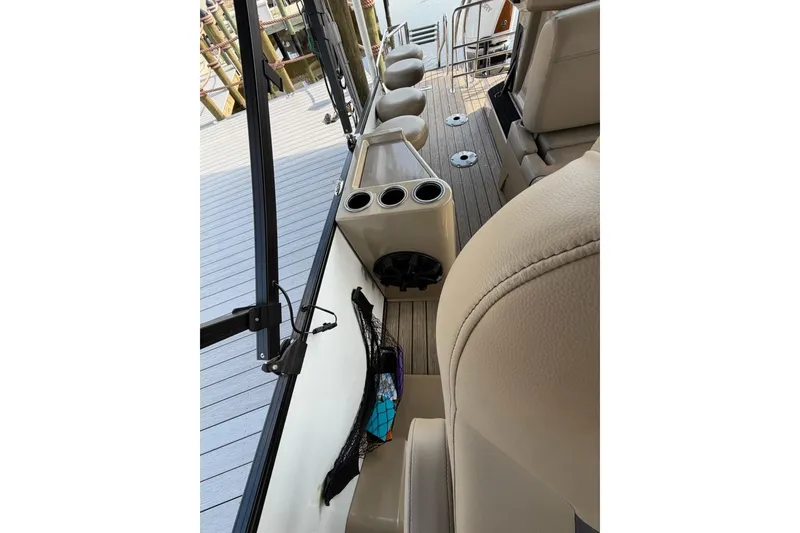 Slide: The Image of 2022 Starcraft CX 25 DL BAR boat interior with beige seating and cup holders. - 11