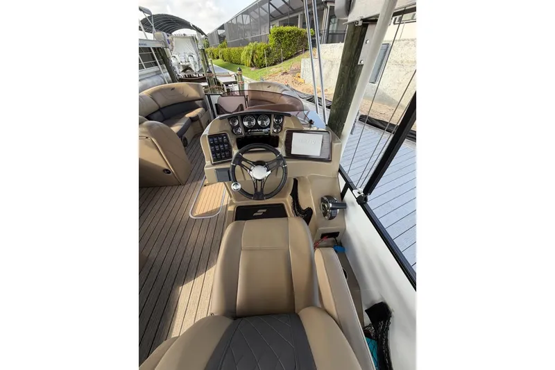 Slide: The Image of Interior view of 2022 Starcraft CX 25 DL BAR boat, featuring steering console and seating. - 12