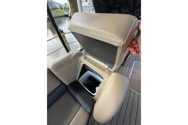Slide: The Image of 2022 Starcraft CX 25 DL BAR boat seat with storage compartment open, dockside view. - 15