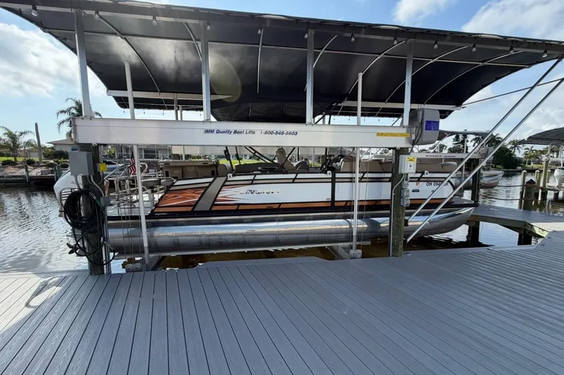 Slide: The Image of 2022 Starcraft CX 25 DL BAR pontoon boat on a lift at a marina. - 16