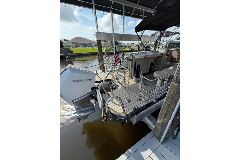 Slide: The Image of 2022 Starcraft CX 25 DL BAR pontoon boat with Mercury engine docked at marina. - 17