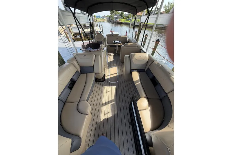 Slide: The Image of Luxurious 2022 Starcraft CX 25 DL BAR pontoon boat interior with plush seating and scenic waterway view. - 18