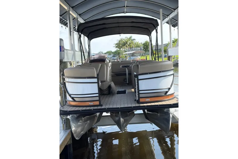 Slide: The Image of 2022 Starcraft CX 25 DL BAR pontoon boat docked under a canopy. - 22