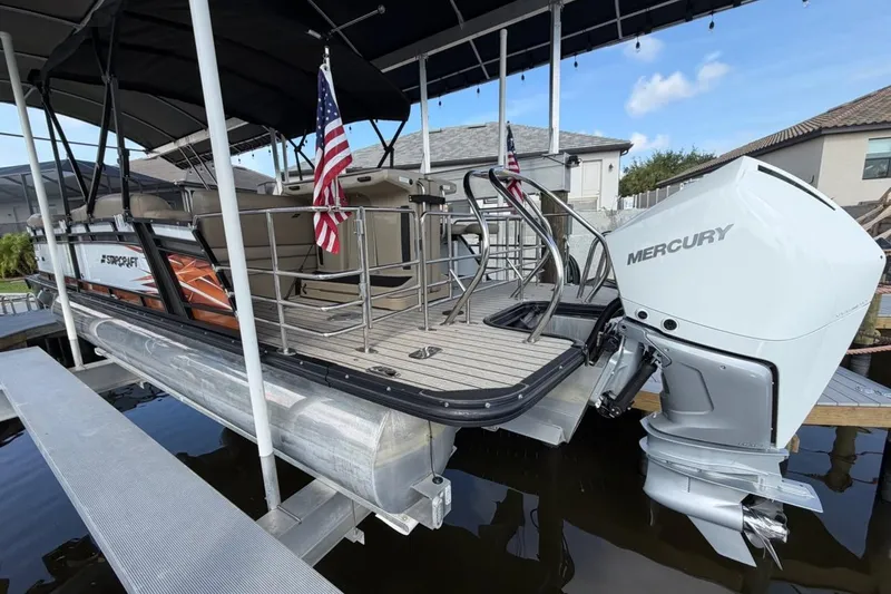 Slide: The Image of 2022 Starcraft CX 25 DL BAR pontoon boat with Mercury outboard motor docked. - 23