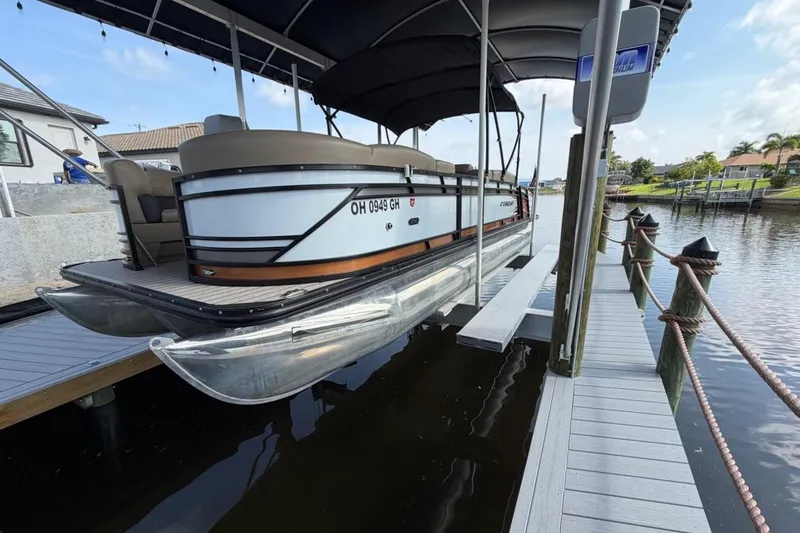 Slide: The Image of 2022 Starcraft CX 25 DL BAR pontoon boat docked at a marina. - 24