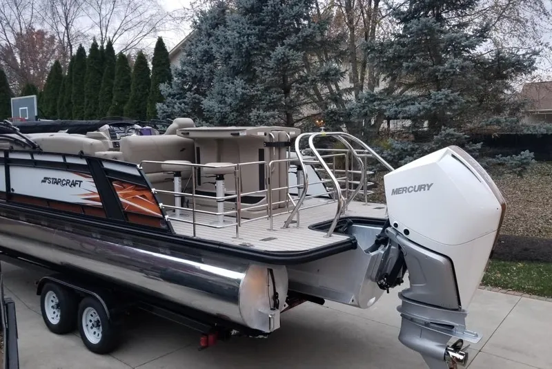 Slide: The Image of 2022 Starcraft CX 25 DL BAR pontoon boat with Mercury outboard motor on trailer. - 3