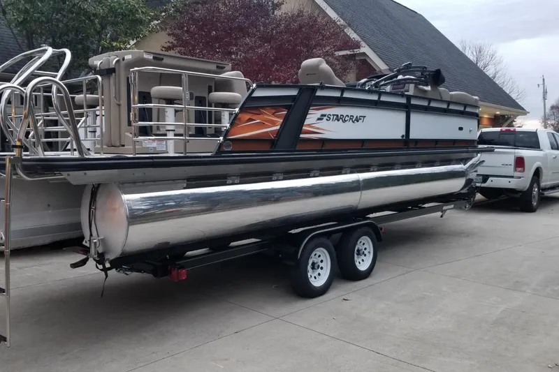 Slide: The Image of 2022 Starcraft CX 25 DL BAR pontoon boat on trailer, parked in driveway. - 4