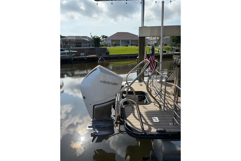 Slide: The Image of 2022 Starcraft CX 25 DL BAR pontoon boat with Mercury outboard engine docked by waterfront. - 7