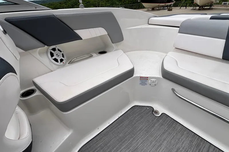 Slide: The Image of 2021 Chaparral 23 SSi boat interior with white and gray seating, speaker, and cup holders. - 15