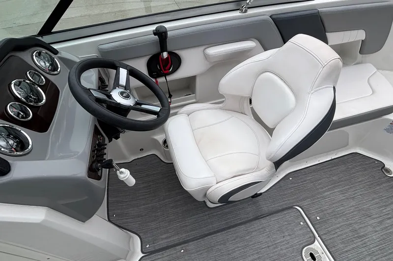 Slide: The Image of 2021 Chaparral 23 SSi boat interior with steering wheel and white captain's chair. - 23