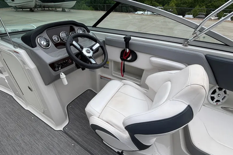 Slide: The Image of 2021 Chaparral 23 SSi boat cockpit with steering wheel and white captain's chair. - 24