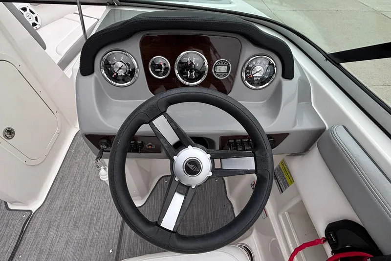 Slide: The Image of 2021 Chaparral 23 SSi boat dashboard with steering wheel and gauges. - 26