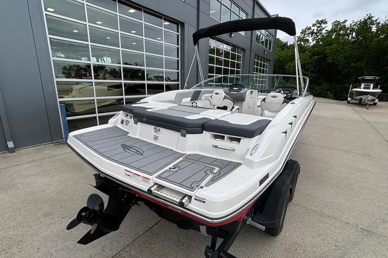 Slide: The Image of 2021 Chaparral 23 SSi boat with sleek design, parked outside showroom. - 3