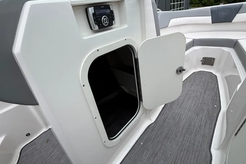Slide: The Image of 2021 Chaparral 23 SSi boat interior with open storage compartment and audio system. - 33