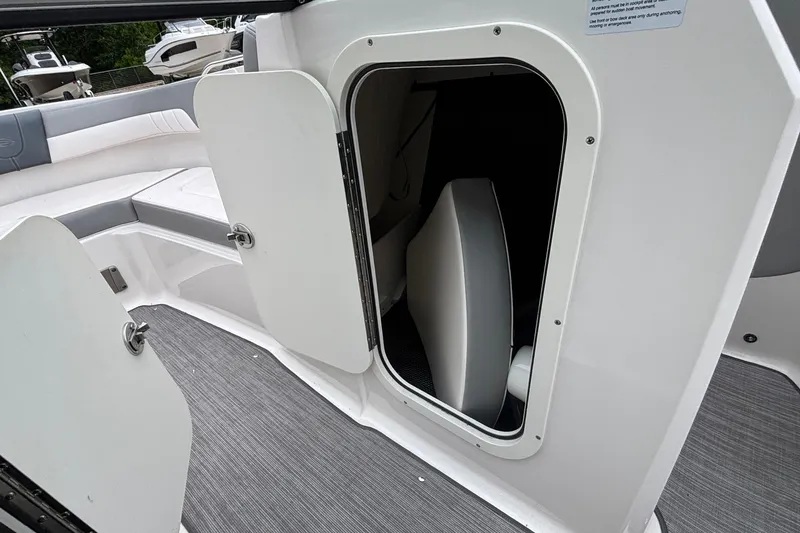 Slide: The Image of 2021 Chaparral 23 SSi boat interior storage compartment with open door. - 34