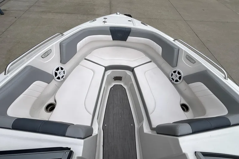 Slide: The Image of 2021 Chaparral 23 SSi boat interior with gray and white seating, featuring speakers and cup holders. - 39