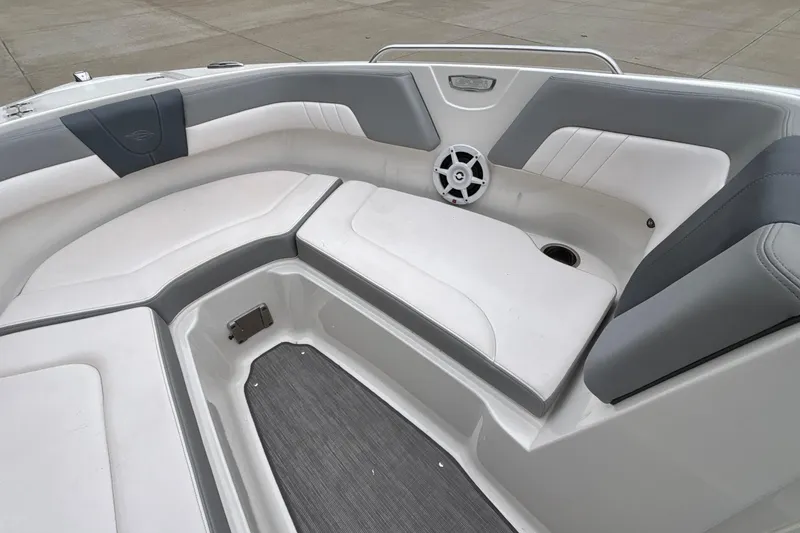 Slide: The Image of 2021 Chaparral 23 SSi boat interior with white and gray seating, featuring a speaker. - 40