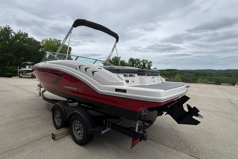 Slide: The Image of 2021 Chaparral 23 SSi boat on trailer, parked outdoors under cloudy sky. - 46