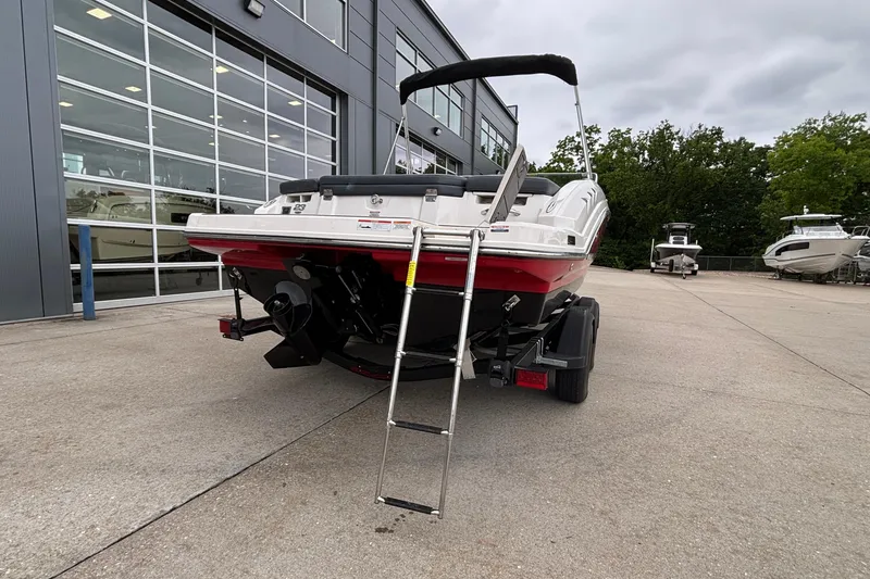 Slide: The Image of 2021 Chaparral 23 SSi boat rear view with ladder, parked outside dealership. - 6