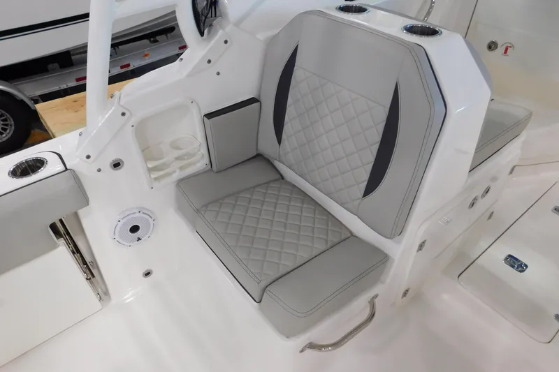 Slide: The Image of 2022 Pursuit DC 266 Dual Console boat interior with cushioned seating and cup holders. - 13