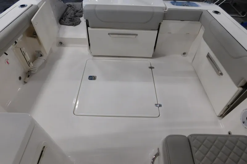 Slide: The Image of 2022 Pursuit DC 266 Dual Console boat interior with storage compartments and seating. - 15