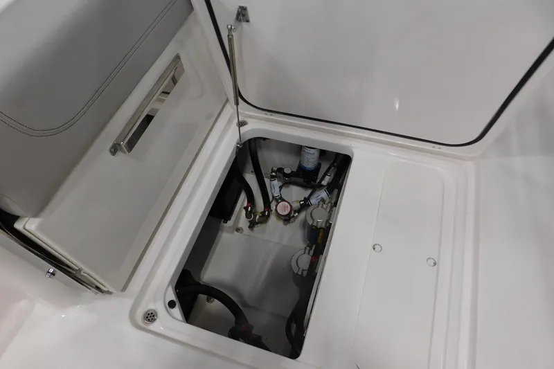 Slide: The Image of Open storage compartment in 2022 Pursuit DC 266 Dual Console boat, showing internal components. - 19