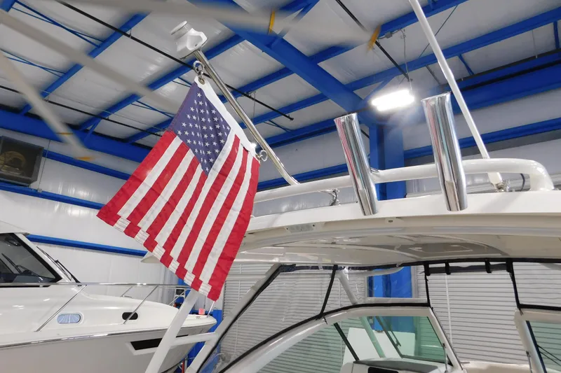 Slide: The Image of 2022 Pursuit DC 266 Dual Console with American flag in a showroom. - 23
