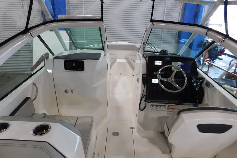 Slide: The Image of 2022 Pursuit DC 266 Dual Console boat interior with steering wheel and seating. - 24
