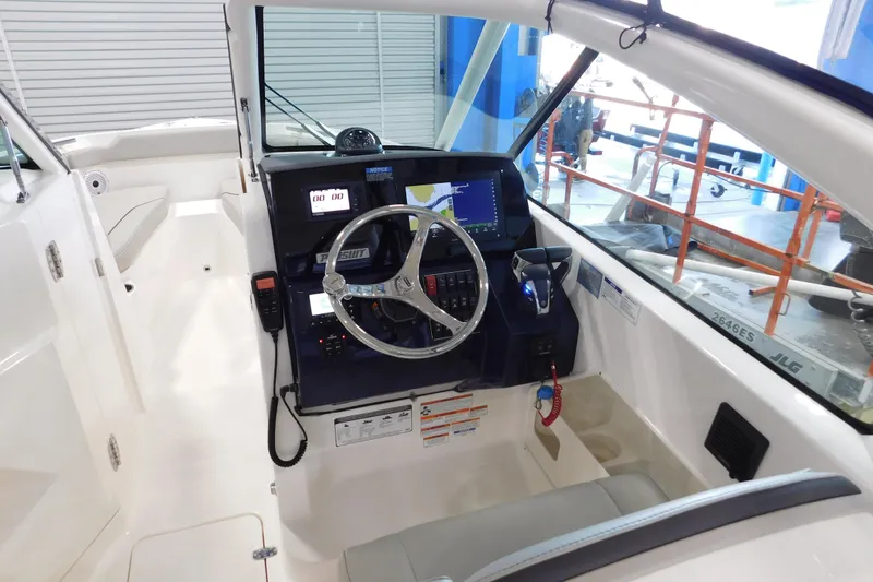 Slide: The Image of 2022 Pursuit DC 266 Dual Console boat interior with steering wheel and control panel. - 26