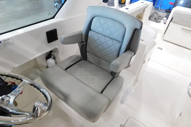 Slide: The Image of Luxury seating on 2022 Pursuit DC 266 Dual Console boat, featuring quilted upholstery and armrests. - 27