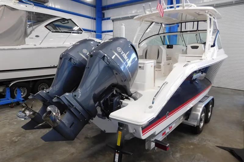 Slide: The Image of 2022 Pursuit DC 266 Dual Console boat with twin Yamaha outboard engines in a showroom. - 3