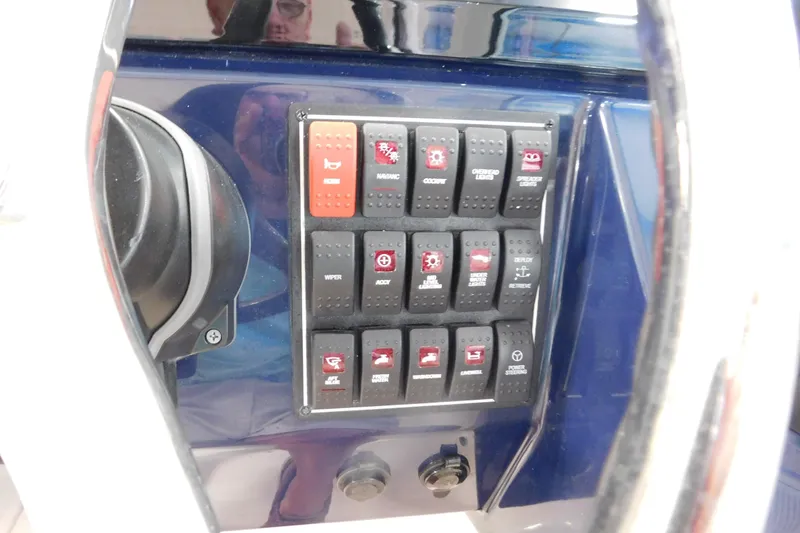 Slide: The Image of Control panel of a 2022 Pursuit DC 266 Dual Console boat with labeled switches. - 34