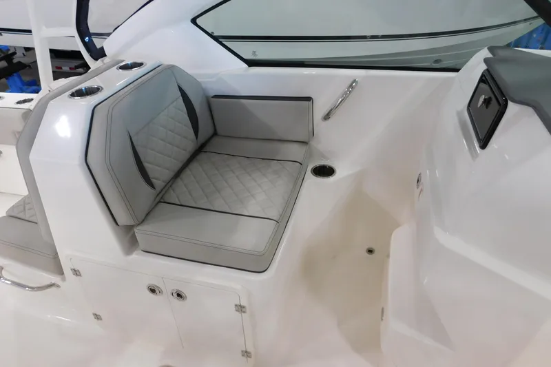 Slide: The Image of 2022 Pursuit DC 266 Dual Console boat interior with cushioned seating and cup holders. - 35