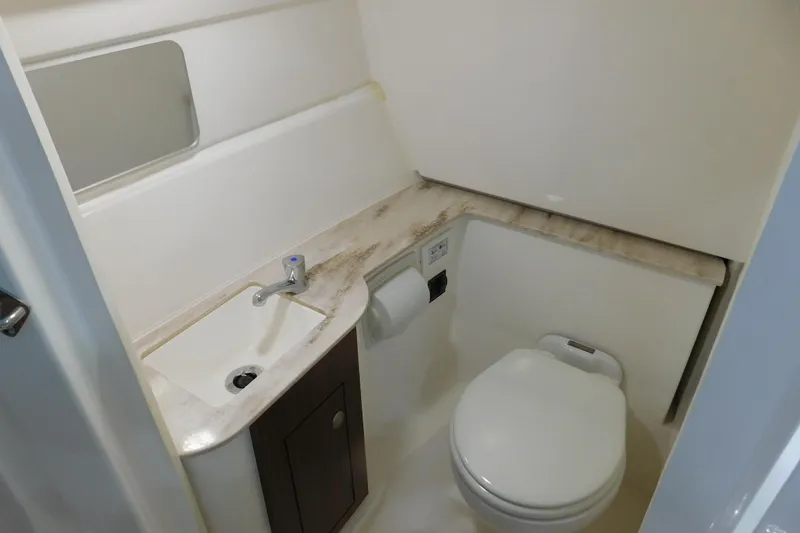 Slide: The Image of 2022 Pursuit DC 266 Dual Console boat bathroom with sink, toilet, and mirror. - 37
