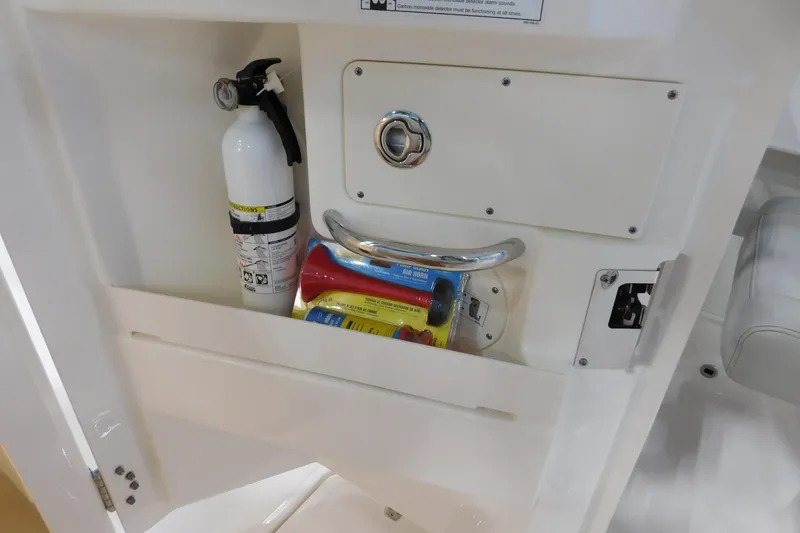 Slide: The Image of 2022 Pursuit DC 266 Dual Console storage with fire extinguisher and air horn. - 39