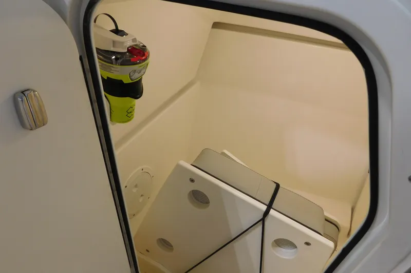 Slide: The Image of Storage compartment inside 2022 Pursuit DC 266 Dual Console boat, featuring safety equipment. - 41