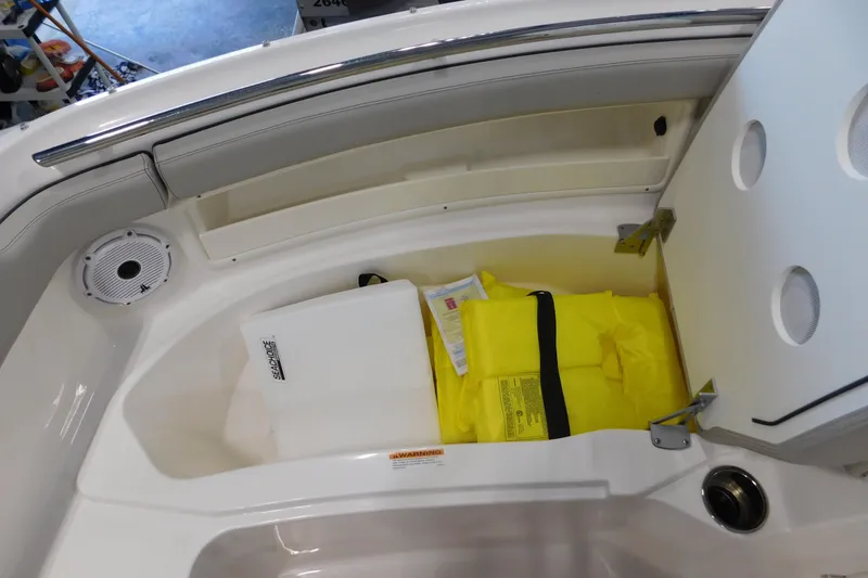 Slide: The Image of Storage compartment on 2022 Pursuit DC 266 Dual Console with life jackets and equipment. - 47