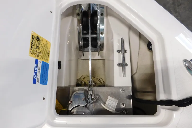 Slide: The Image of Anchor compartment of 2022 Pursuit DC 266 Dual Console boat with warning labels. - 48